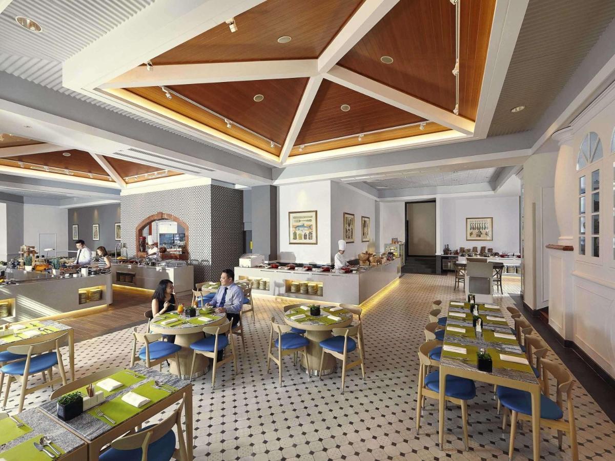 Paradox Singapore Merchant Court At Clarke Quay Εξωτερικό φωτογραφία The photo depicts a modern restaurant interior. The space features a stylish design with a high ceiling and wooden details, creating an inviting atmosphere. 

Tables are neatly arranged, each set with green placemats and blue chairs. There is a secti