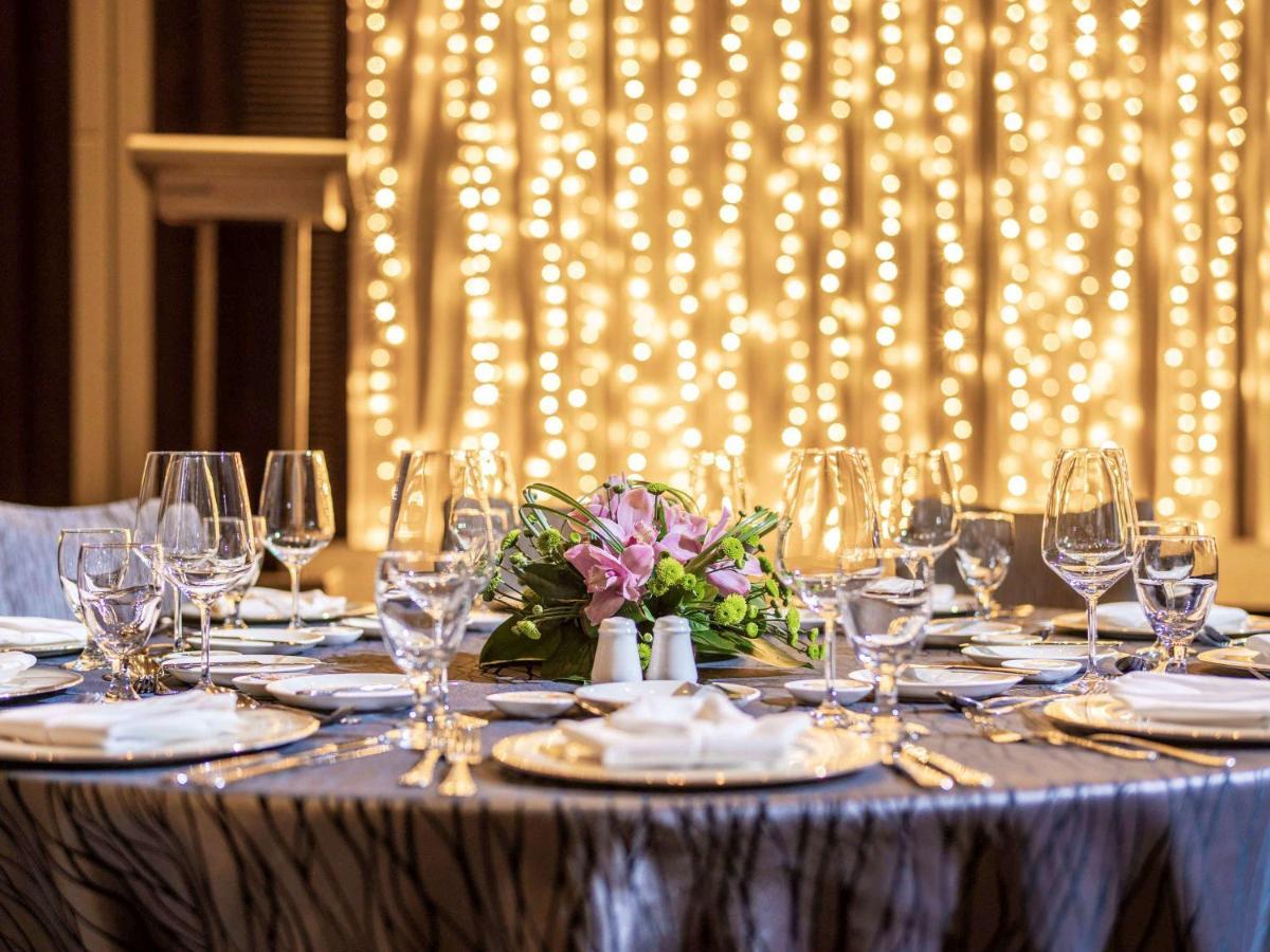 Paradox Singapore Merchant Court At Clarke Quay Εξωτερικό φωτογραφία The image shows a beautifully set dining table, elegantly arranged for a special event or celebration. The table is covered with a stylish cloth, and there are several plates, glasses, and utensils neatly placed around it. In the center, there's a fl