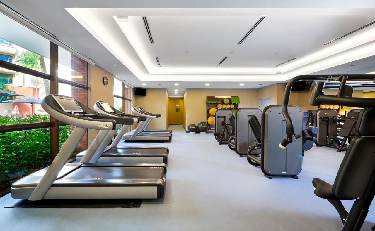 Paradox Singapore Merchant Court At Clarke Quay Εξωτερικό φωτογραφία The photo depicts an indoor gym or fitness area. There are several modern treadmills lined up against one wall, with large windows allowing natural light to enter. The gym features various fitness machines arranged throughout the space, including str