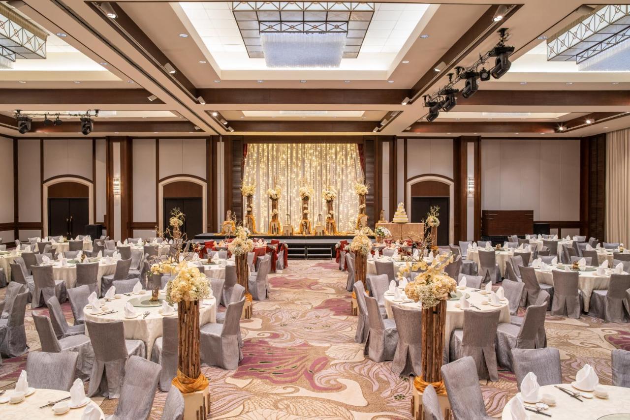 Paradox Singapore Merchant Court At Clarke Quay Εξωτερικό φωτογραφία The photo shows an elegantly arranged banquet or event hall. There are several round tables covered with white tablecloths and decorated with floral centerpieces, creating a sophisticated atmosphere. The chairs are covered in grey fabric, complementi