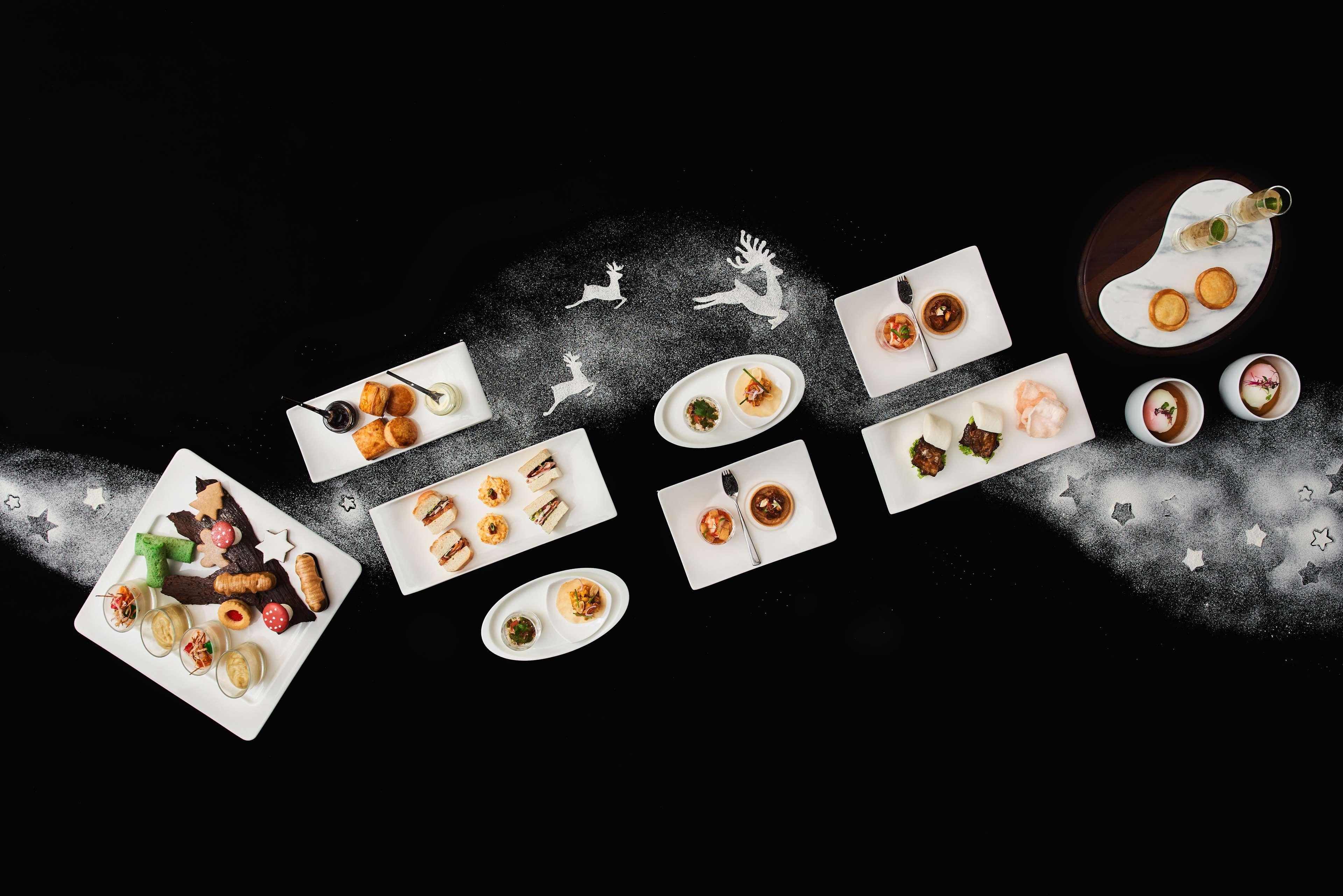 Paradox Singapore Merchant Court At Clarke Quay Εξωτερικό φωτογραφία The photo showcases an elegant arrangement of various dishes presented on white plates, set against a dark background. The dishes include an assortment of culinary items, possibly desserts and appetizers, artistically plated and garnished. There are 