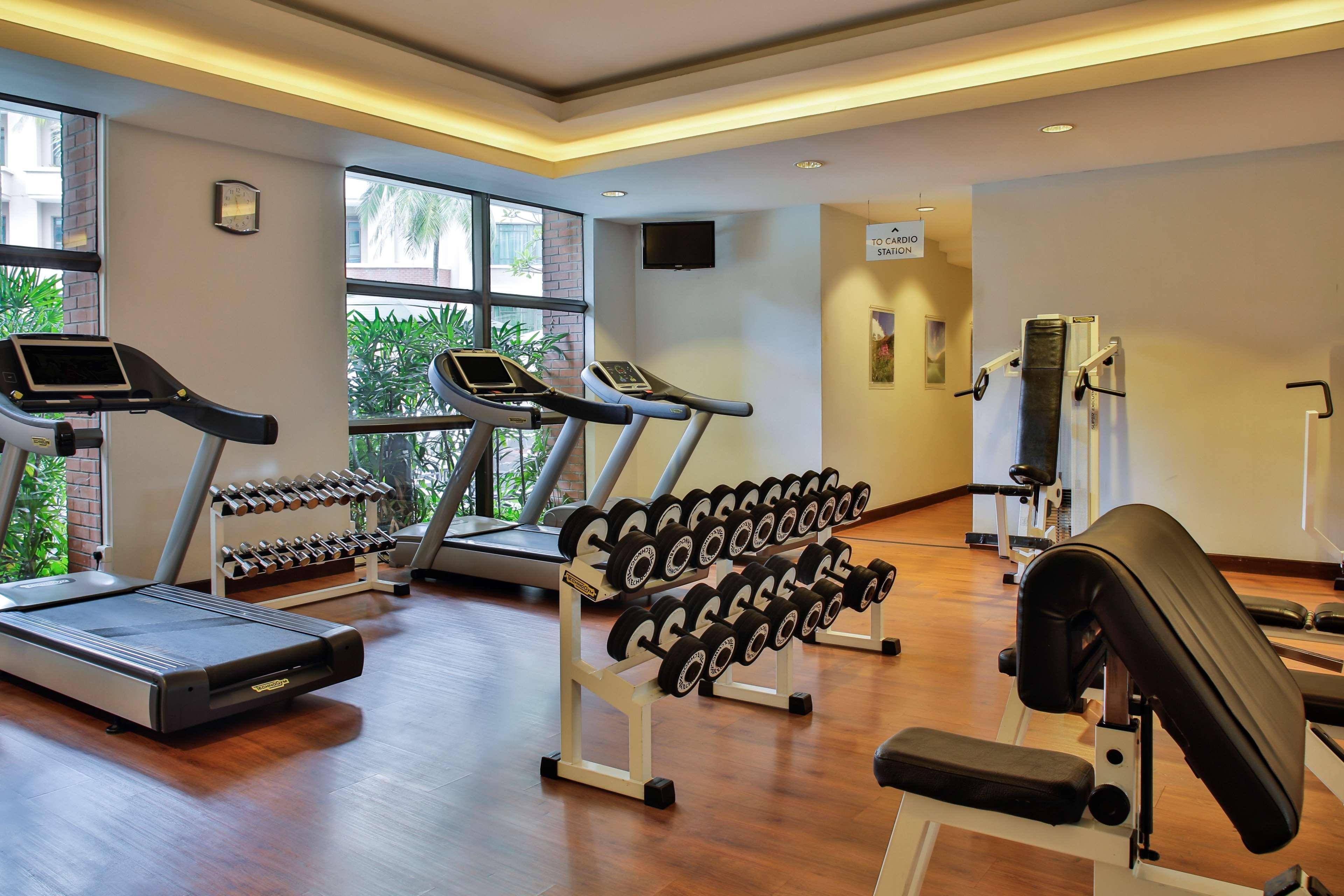 Paradox Singapore Merchant Court At Clarke Quay Εξωτερικό φωτογραφία The photo shows a gym or fitness area featuring various exercise equipment. There are two treadmills positioned near a window, allowing natural light to brighten the space. A set of dumbbells is neatly organized on a rack, prominently displayed. Addi