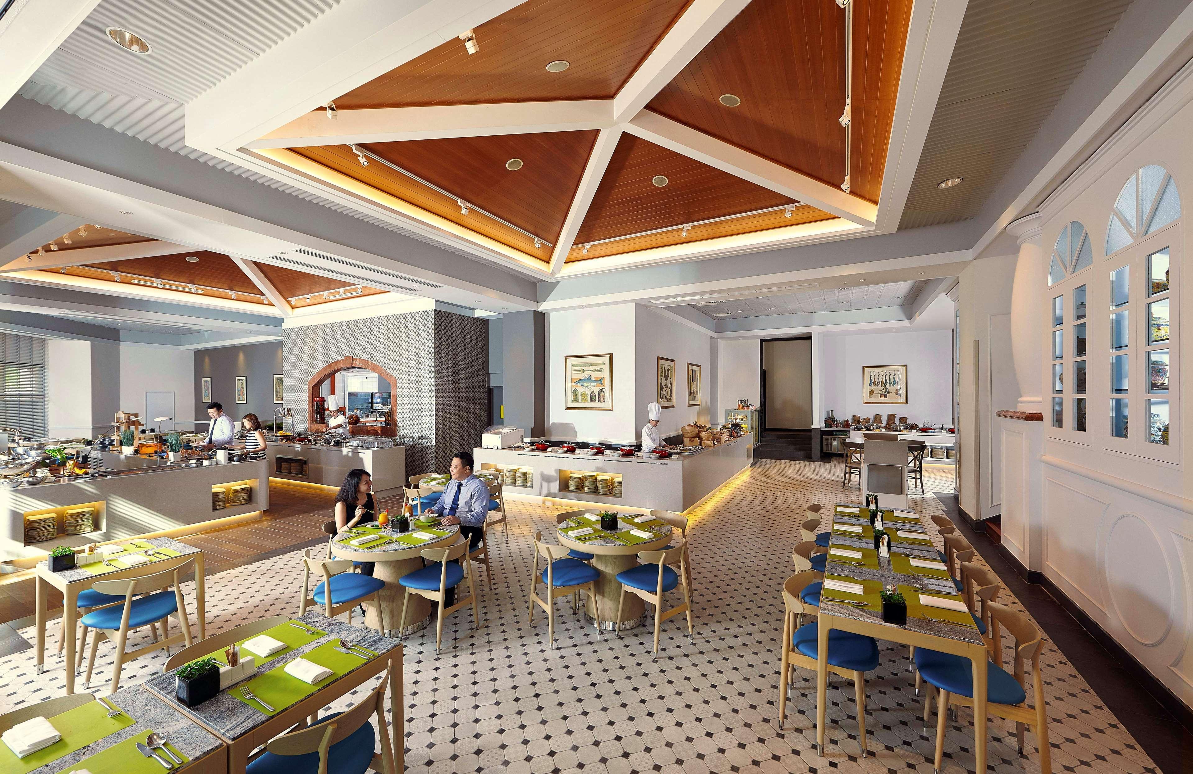 Paradox Singapore Merchant Court At Clarke Quay Εξωτερικό φωτογραφία The photo shows a modern restaurant interior with a spacious layout. The ceiling features a geometric wooden design, adding a touch of elegance. The floor has a checkered pattern, contributing to the decor's stylish feel. 

There are several tables a