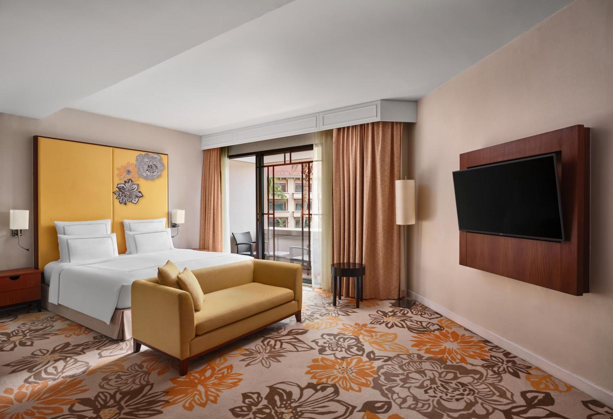Paradox Singapore Merchant Court At Clarke Quay Εξωτερικό φωτογραφία The photo shows a modern hotel room featuring:

- A queen or king-sized bed with white bedding against a bright yellow wall.
- A cozy yellow sofa placed in front of the bed.
- A plush carpet with floral designs in warm colors.
- Large windows with be